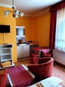 赫维兹Apart Júlia Villa的一间带红色椅子的客厅和一间厨房