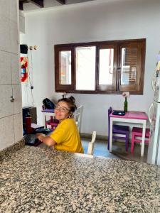 萨尔塔Esperanto hostel的坐在厨房柜台上的女人