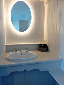 杜林Fairwinds Guest Accommodation的一间带水槽和圆镜子的浴室