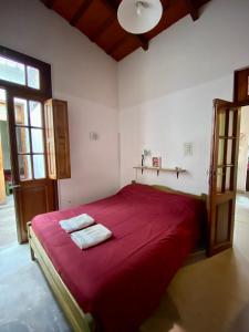 萨尔塔Esperanto hostel的一间卧室配有红色的床和2条毛巾