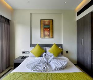 特里凡得琅Ariya Nivaas A Vegetarian Hotel的一间卧室配有白色床和黄色枕头