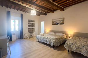 费拉约港Residenza Portoferraio的一间卧室设有两张床,铺有木地板