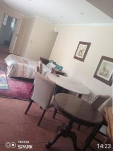 约翰内斯堡50 Arklow的客厅配有桌子和床。