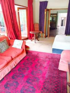 约翰内斯堡50 Arklow的客厅配有红色沙发和红色地毯