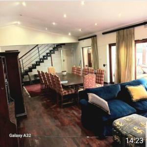 约翰内斯堡50 Arklow的客厅配有蓝色的沙发和桌子