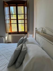 基安蒂格雷夫威驰优玛叶儿城堡酒店的一张带四个枕头的床和窗户