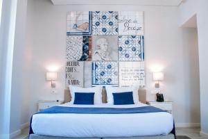 塞图巴尔里约艺术酒店的一间卧室配有一张带蓝色枕头的大床