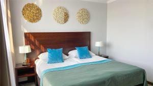 弗罗茨瓦夫欧罗帕姆酒店的一间卧室配有一张带蓝色枕头的大床