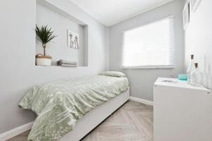 KentSpacious 3 Bedroom Modern House with Garden的白色的卧室设有床和窗户
