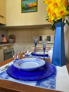 阿杰罗拉Nilu's Central House的一张桌子,上面有两盘盘,蓝色的花瓶