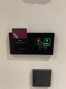 霍夫多普OZO Hotels Antares Airport的墙上的黑盒子,上面有时钟