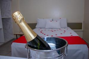 马瑙斯Plaza Prestige Hotel Manaus的睡床旁的桶里一瓶香槟