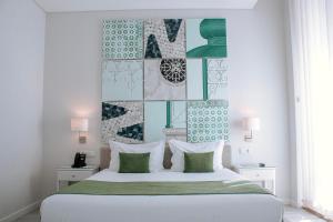 塞图巴尔里约艺术酒店的卧室配有白色床和绿色和白色枕头