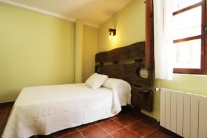 弗里亚斯Hotel Rural Frías的卧室配有白色的床和窗户。