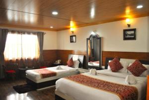 大吉岭Goroomgo Kasturi Palace Darjeeling - Luxury Room with Parking Facilities - Best Seller的一间酒店客房,房间内设有两张床