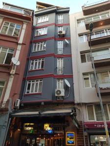 伊斯坦布尔KADIKÖY BRISTOL HOTEL的城市街道上高大的灰色建筑,窗户