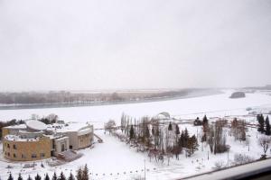 巴甫洛达尔гостиница Павлодар的河边的雪地建筑