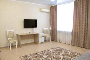 巴甫洛达尔гостиница Павлодар的酒店客房配有电视、书桌和椅子。