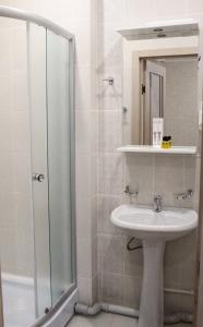 巴甫洛达尔гостиница Павлодар的白色的浴室设有水槽和淋浴。