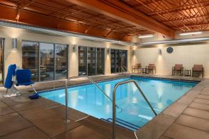 克莱顿克莱顿/圣路易斯 - 广场区汉普顿酒店及套房的酒店的大型室内游泳池配有桌椅