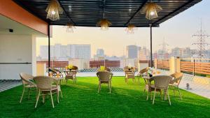 古尔冈ZEN Medicity - Hotel & Serviced Apartments Gurgaon的屋顶上带桌椅的天井