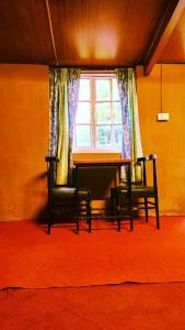 乌提Woodside Bungalow1的窗户间里的一张桌子和两把椅子