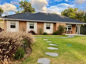 Henley Beach SouthParkview Cottage的庭院前有小路的房子