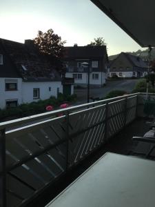 温特贝格松呐黒木膳食公寓酒店的阳台设有木栅栏和房屋。