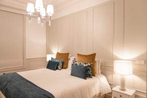 波尔图Porto Deluxe Palace的卧室配有带蓝色枕头的大型白色床