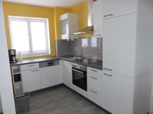 巴特温茨海姆Ferienwohnungen Flora的厨房配有白色橱柜和水槽