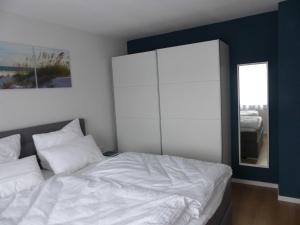 巴特温茨海姆Ferienwohnungen Flora的卧室配有白色的床和镜子