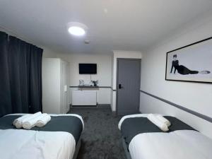 阿克斯桥OYO Greenway Stays的酒店客房设有两张床和电视。