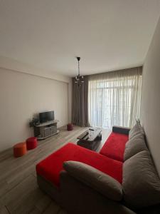第比利斯Cozy Apartment - LEODORA的客厅,窗户前设有红色沙发