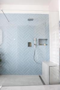 顺佩尔克Apartmán v centru的浴室设有蓝色瓷砖墙和淋浴。