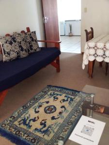 克兰威廉Biedouw Padstal & Toerisme的客厅配有蓝色的沙发和地毯。