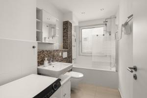 沃尔夫斯堡FREE LIVING - Jungle Design Apartments, Zentrum, Parkplatz, Küche, Wlan的白色的浴室设有卫生间和水槽。