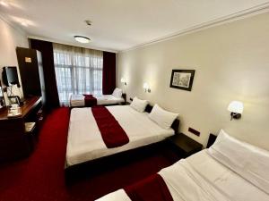 斯科普里Hotel Hamburg的酒店客房配有两张床和一张书桌