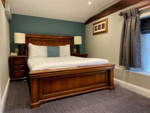 威布里治贝斯特韦斯特西普酒店的一间卧室设有一张木床和一个窗户。