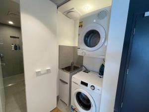 布里斯班Modern Homely 2BR APT w Parking Bowen Hills的一间带洗衣机和洗衣机的浴室