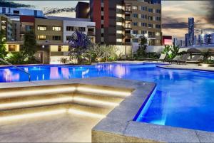 布里斯班Modern Homely 2BR APT w Parking Bowen Hills的大楼内一个蓝色的大型游泳池
