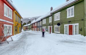 BjorliNice Apartment In Bjorli With Wifi的滑雪者在建筑物旁边的雪街道上