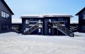 伊德勒Awesome Apartment In Idre With House A Panoramic View的前面的地面上积雪的建筑