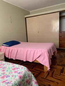 皮斯科Habitación doble的一间卧室配有两张带粉红色床单的床和梳妆台。