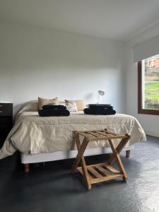 乌斯怀亚Las Lavandas的白色卧室配有一张带木桌的床