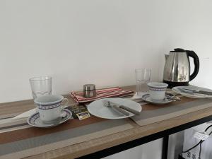乌斯怀亚Las Lavandas的桌子,桌子上放着两个杯子和盘子,还有咖啡壶