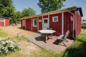 于克里茨Herzmuschel的红色小屋,甲板上配有野餐桌和椅子
