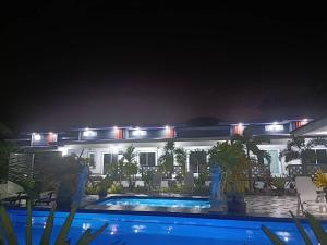 Ban Nai RaiMB House的一座晚上设有游泳池的房子
