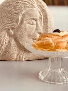 泰尔莫利FUTURA ROOM&RELAX的雕像旁盘子里的糕点