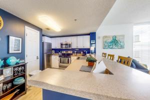 巴拿马城海滩Majestic Beach Resort Tower 1 #915的一间厨房,拥有蓝色的墙壁和大台面