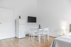 维也纳Attractive 2 BR Apt. near Vienna AKH Ideal for All的白色的客房配有桌椅和冰箱。